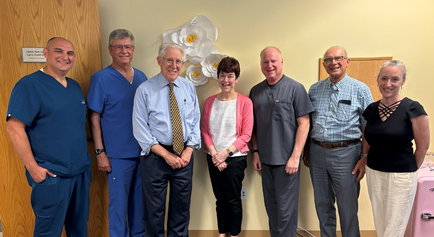 a group of seven medical professionals smiling at the camera